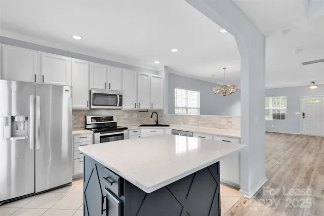 a kitchen with stainless steel appliances a stove a sink a refrigerator and cabinets
