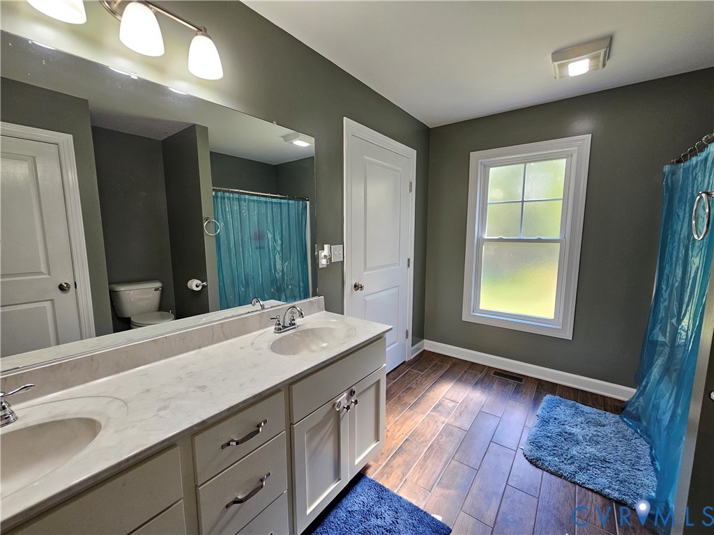 3286 Ranson Road Dillwyn, VA 23936 - Photo 11 of 25 a spacious bathroom with a granite countertop sink and a large mirror