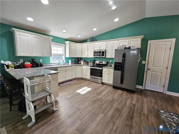 a kitchen with a refrigerator cabinets and wooden floor