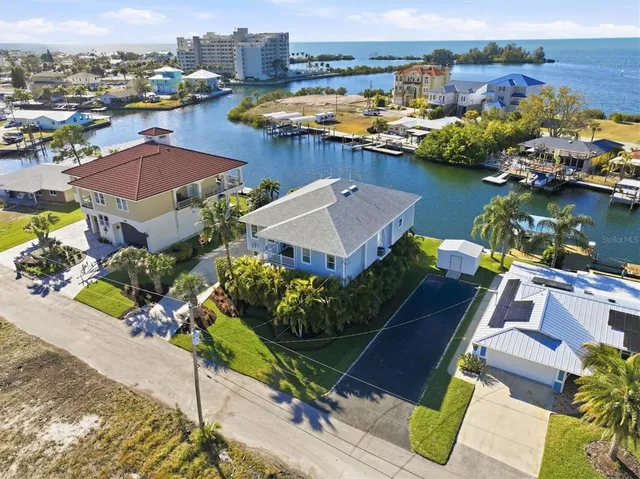 a open kitchen with stainless steel appliances granite countertop a stove top oven a dining table and chairs with wooden floor