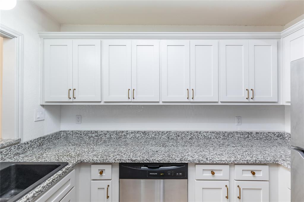 12680 Hillcrest Road, Unit 4101 Dallas, TX 75230 - Photo 15 of 37 Kitchen featuring white shaker-style cabinetry, crown molding, speckled countertops, and a built-in dishwasher