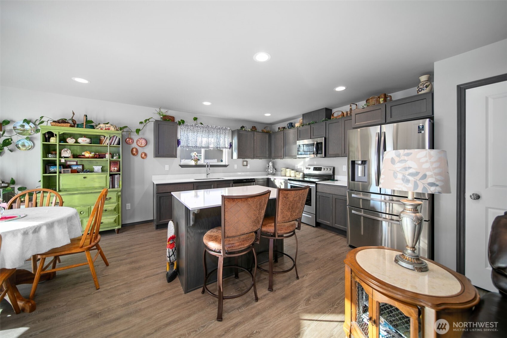 2314 Southeast Marlette Road East Wenatchee, WA 98802 - Photo 8 of 27 a kitchen with stainless steel appliances a table chairs refrigerator and wooden floor