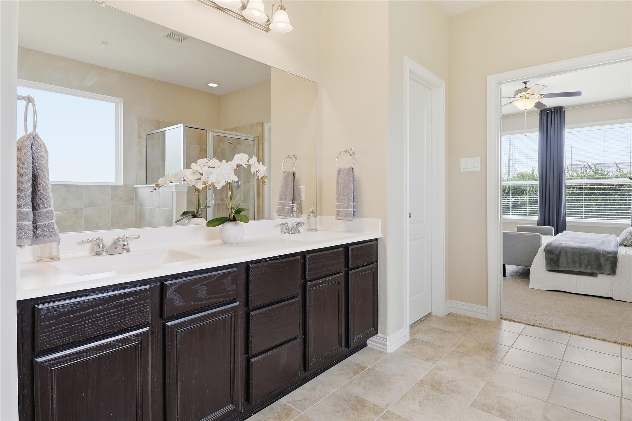 3219 Cotton Ranch Drive Katy, TX 77494 - Photo 20 of 45 An expansive dual-sink vanity offers generous countertop space, rich espresso cabinetry, abundant storage, a wall-to-wall mirror, and elegant vanity lighting.