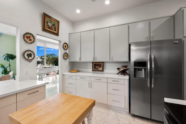 a kitchen with stainless steel appliances a refrigerator sink and white cabinets