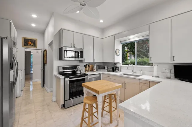 a kitchen with granite countertop a stove sink microwave and refrigerator
