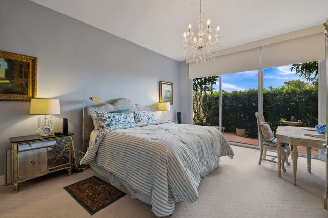 a bedroom with a bed and a chandelier