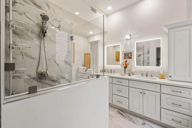a bathroom with a double vanity sink mirror and shower