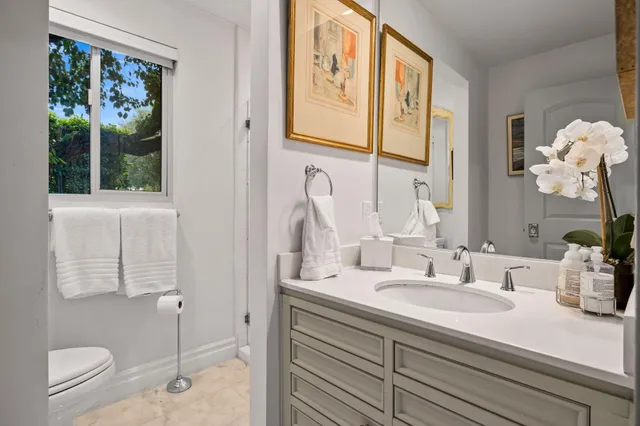 a bathroom with a sink a toilet and a large mirror