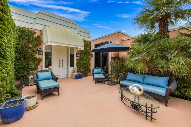 a view of a patio with couches and a table and chairs with wooden floor and fence