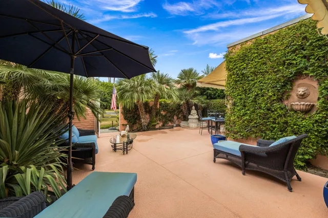 a backyard of a house with table and chairs
