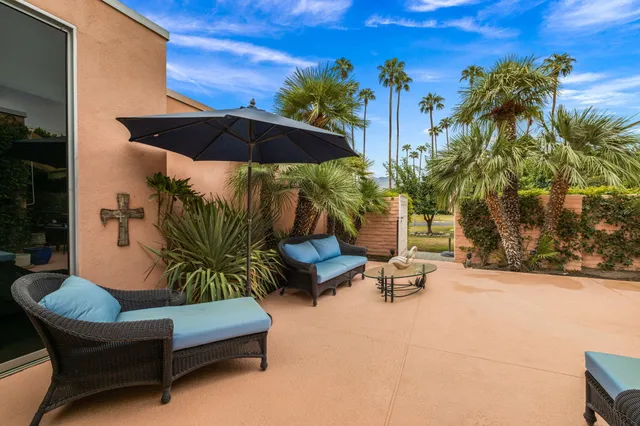 a view of patio with a table and chairs under an umbrella