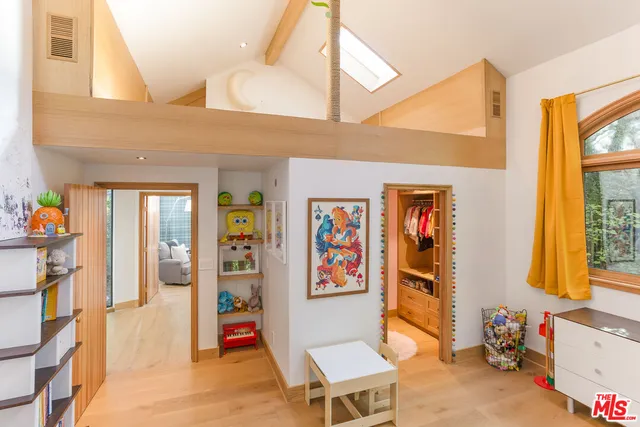 a living room with furniture a baby crib and a window