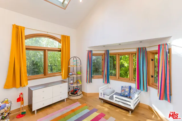 a bedroom with furniture and a large window