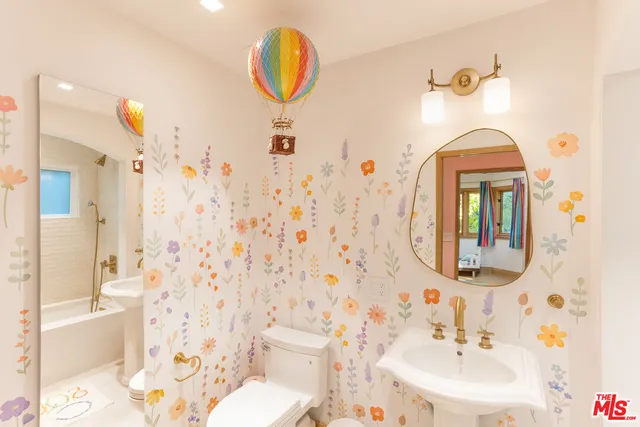 a bathroom with a sink mirror and a toilet