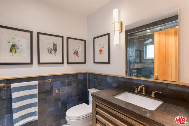 a bathroom with a sink a toilet and mirror