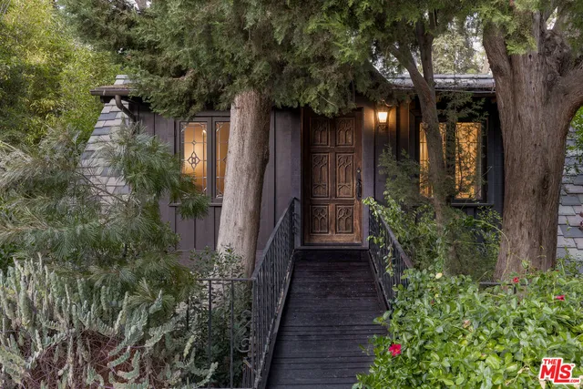 a couple of flower plants in front of yellow house