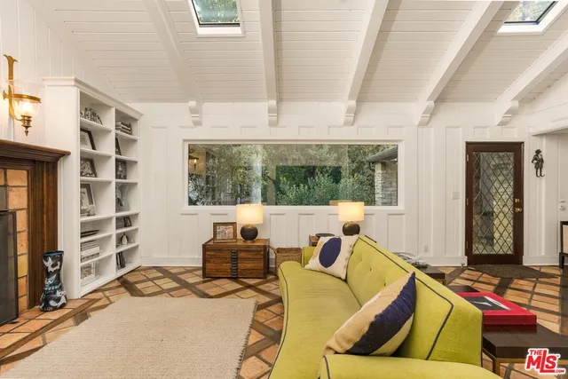 a living room with furniture cabinets and a window