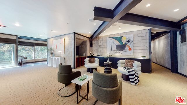 a living room with furniture and a large window with garden view