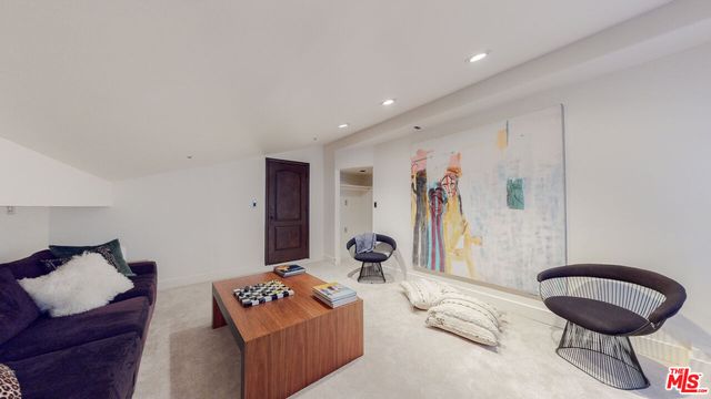 a living room with furniture and a painting on the wall