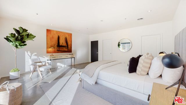 a bedroom with a bed and a painting on the wall