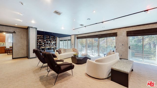 a living room with furniture and large windows