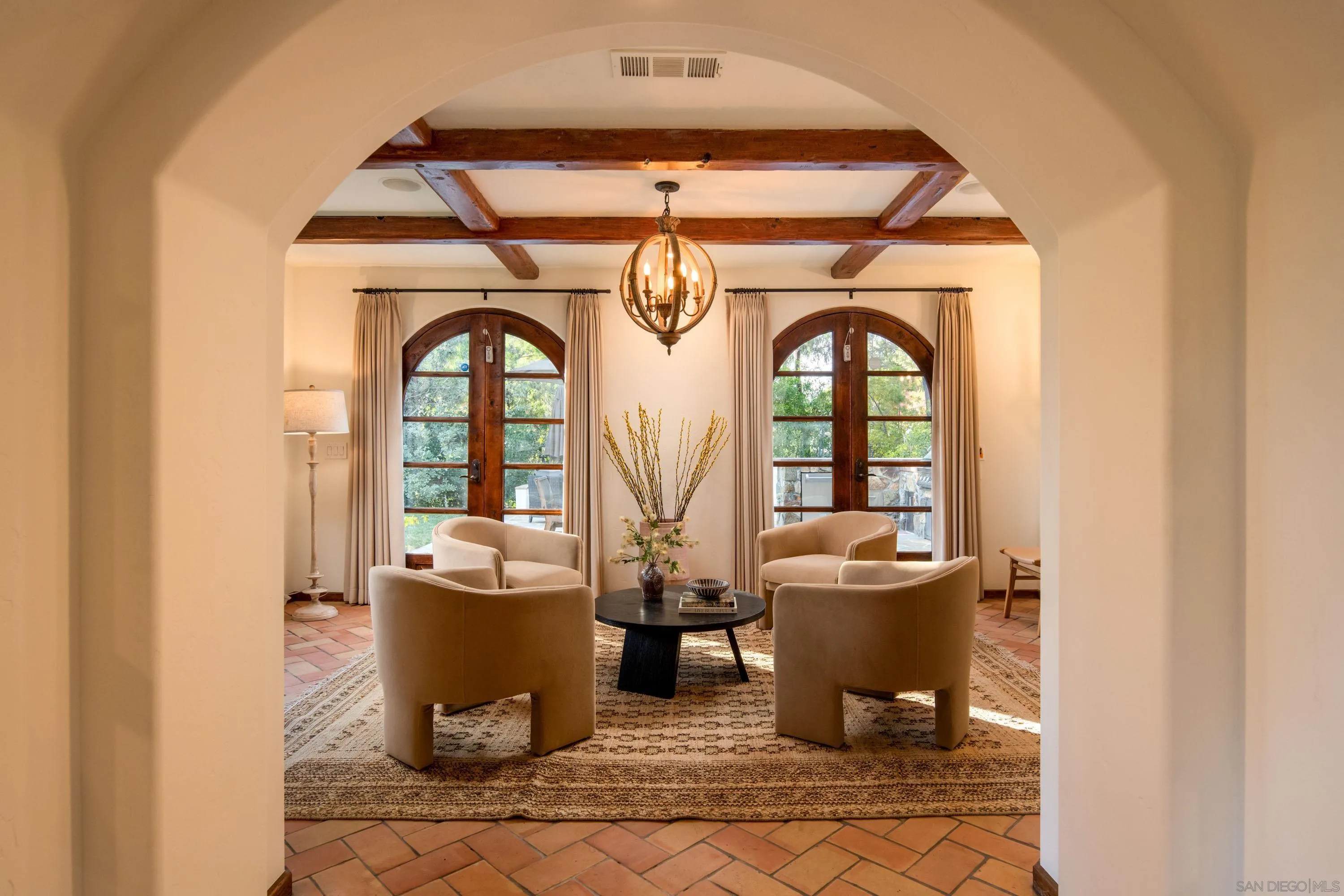 6511 Poco Lago Rancho Santa Fe, CA 92067 - Photo 8 of 24 a living room with a fireplace and a chandelier