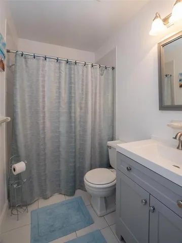 a bathroom with a granite countertop sink toilet and a mirror