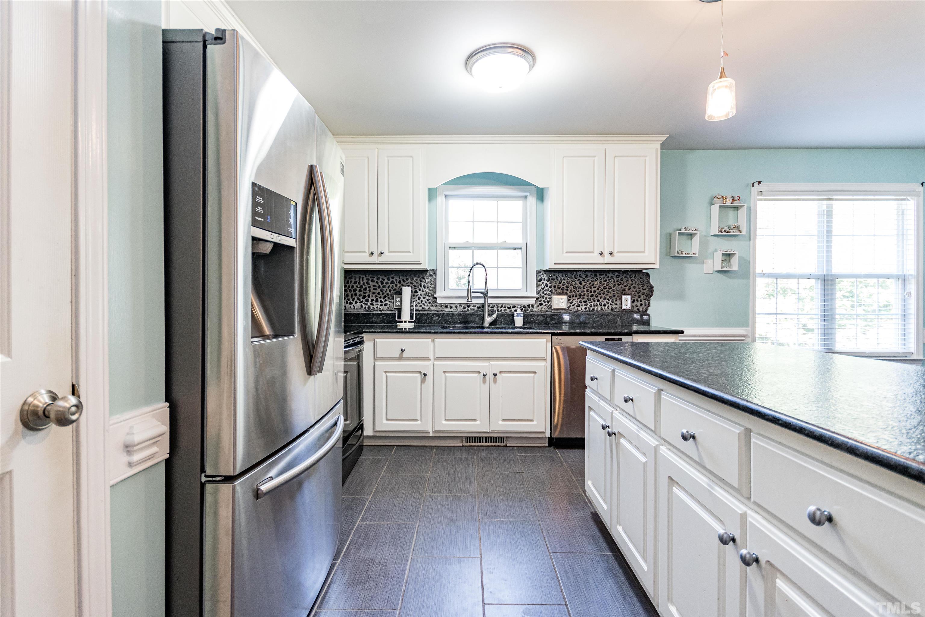 519 Axum Road Willow Spring, NC 27592 - Photo 16 of 30 a kitchen with stainless steel appliances sink a microwave and cabinets