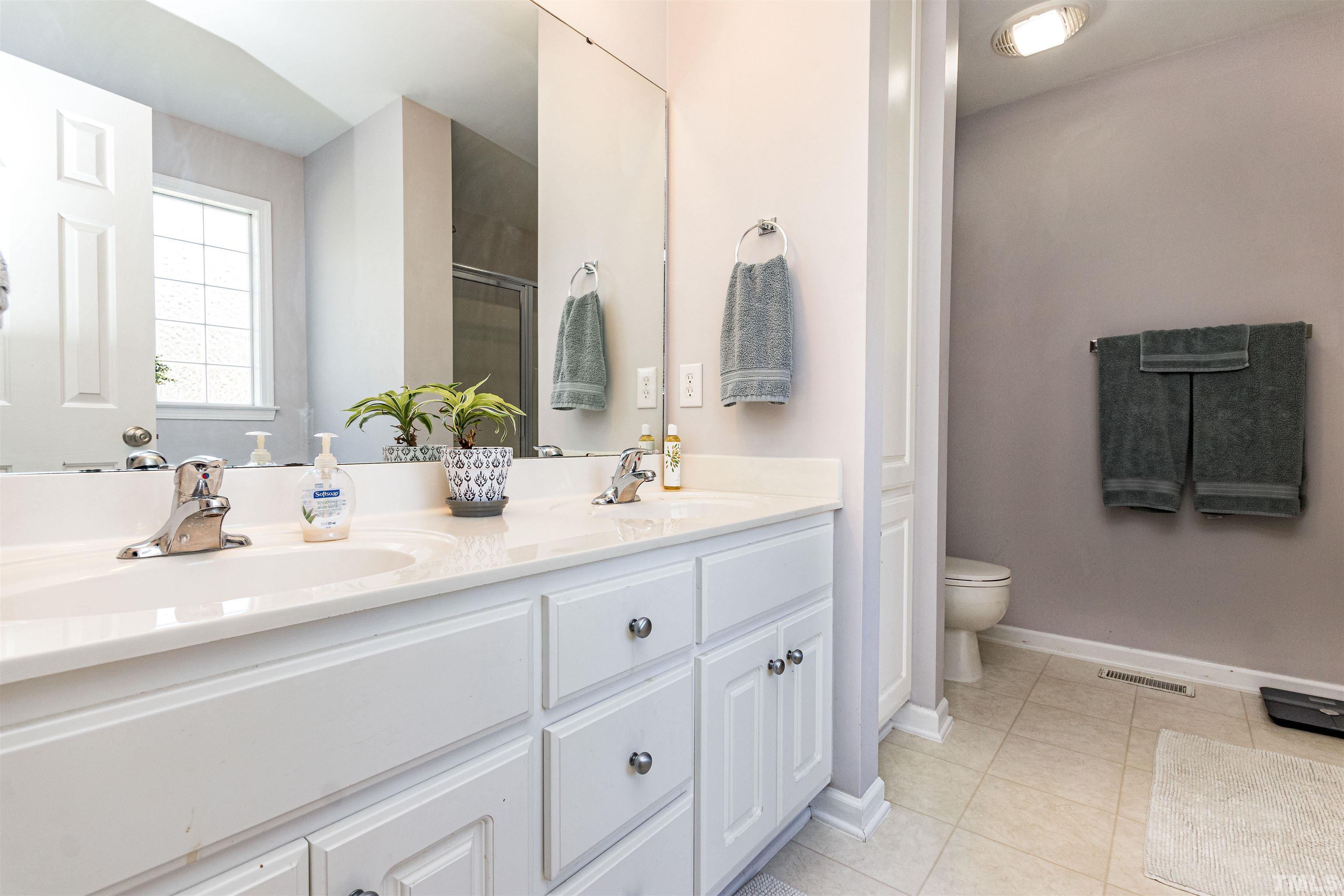 519 Axum Road Willow Spring, NC 27592 - Photo 20 of 30 a bathroom with a double vanity sink and a toilet