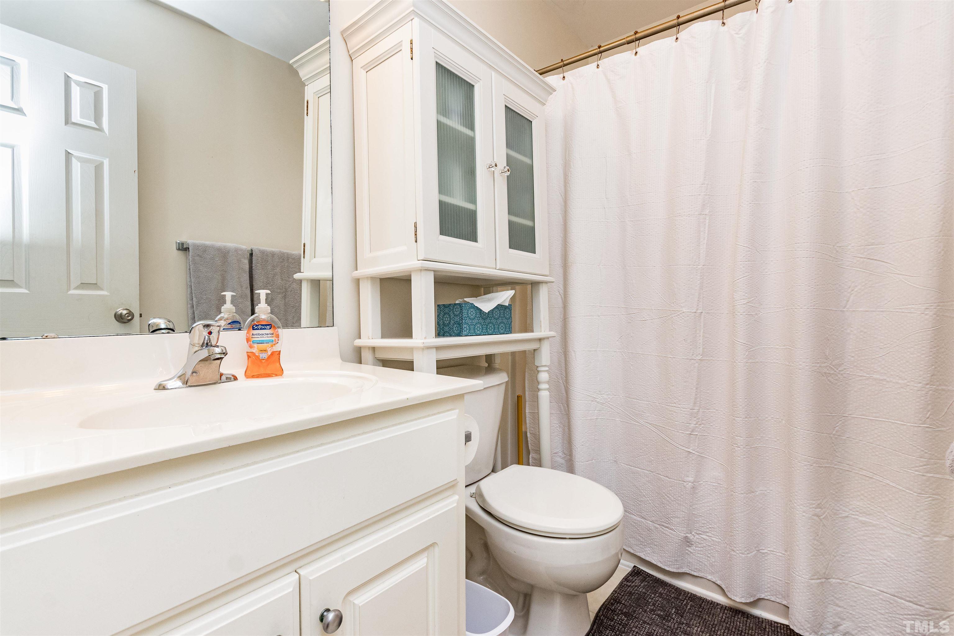 519 Axum Road Willow Spring, NC 27592 - Photo 25 of 30 a bathroom with a sink a toilet and shower curtain
