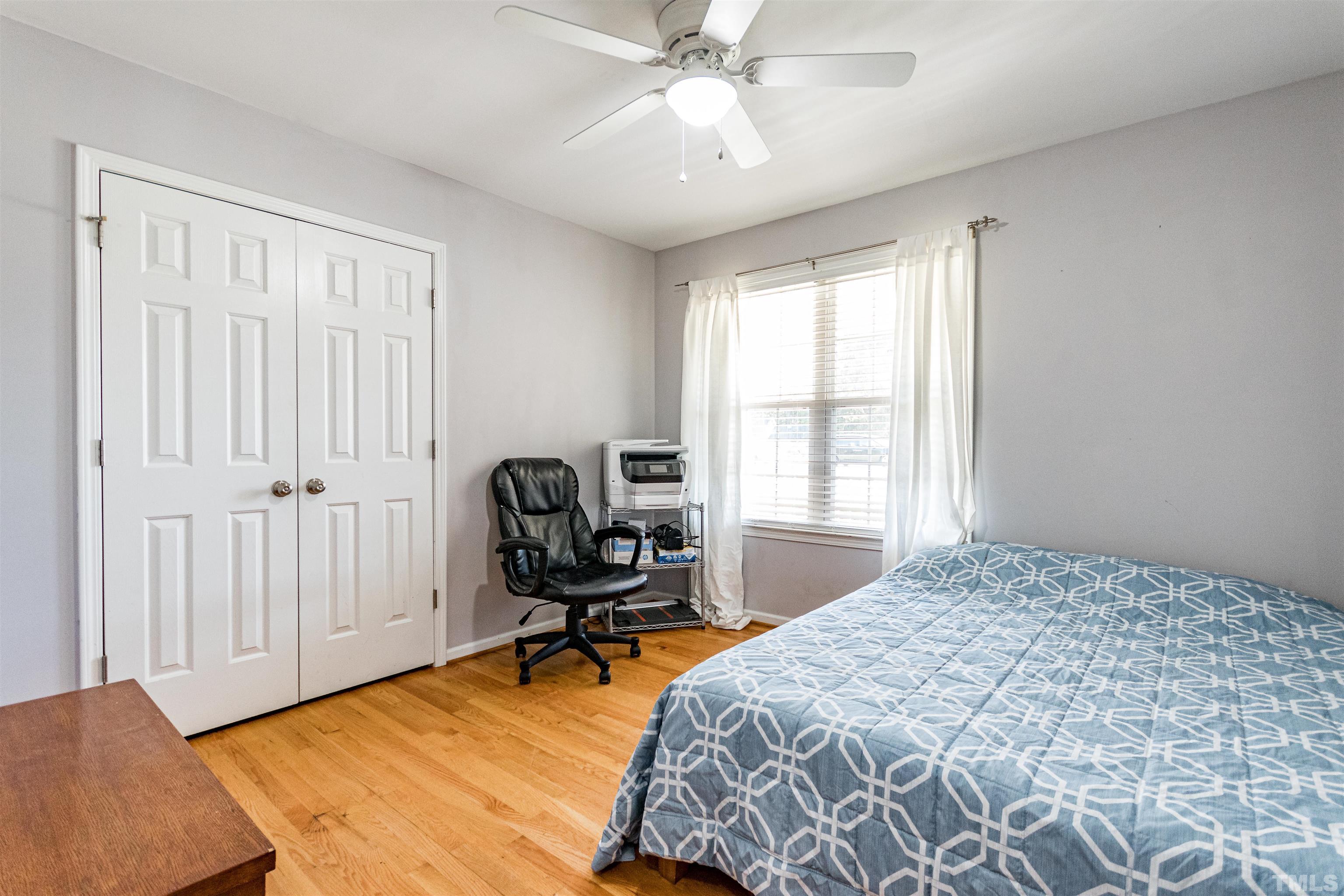 519 Axum Road Willow Spring, NC 27592 - Photo 26 of 30 a bedroom with a bed a chair and a chandelier