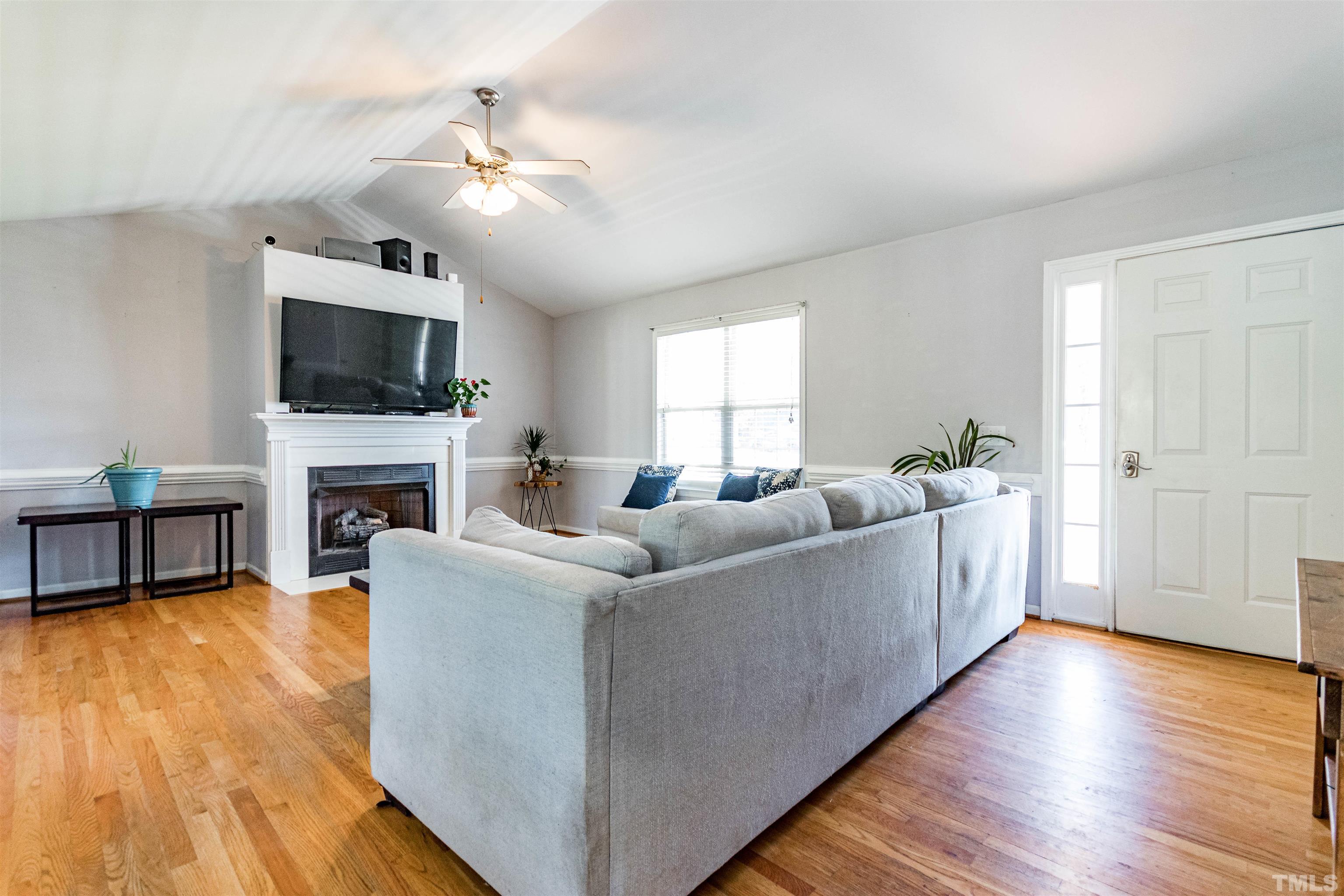 519 Axum Road Willow Spring, NC 27592 - Photo 5 of 30 a living room with furniture a flat screen tv and a fireplace