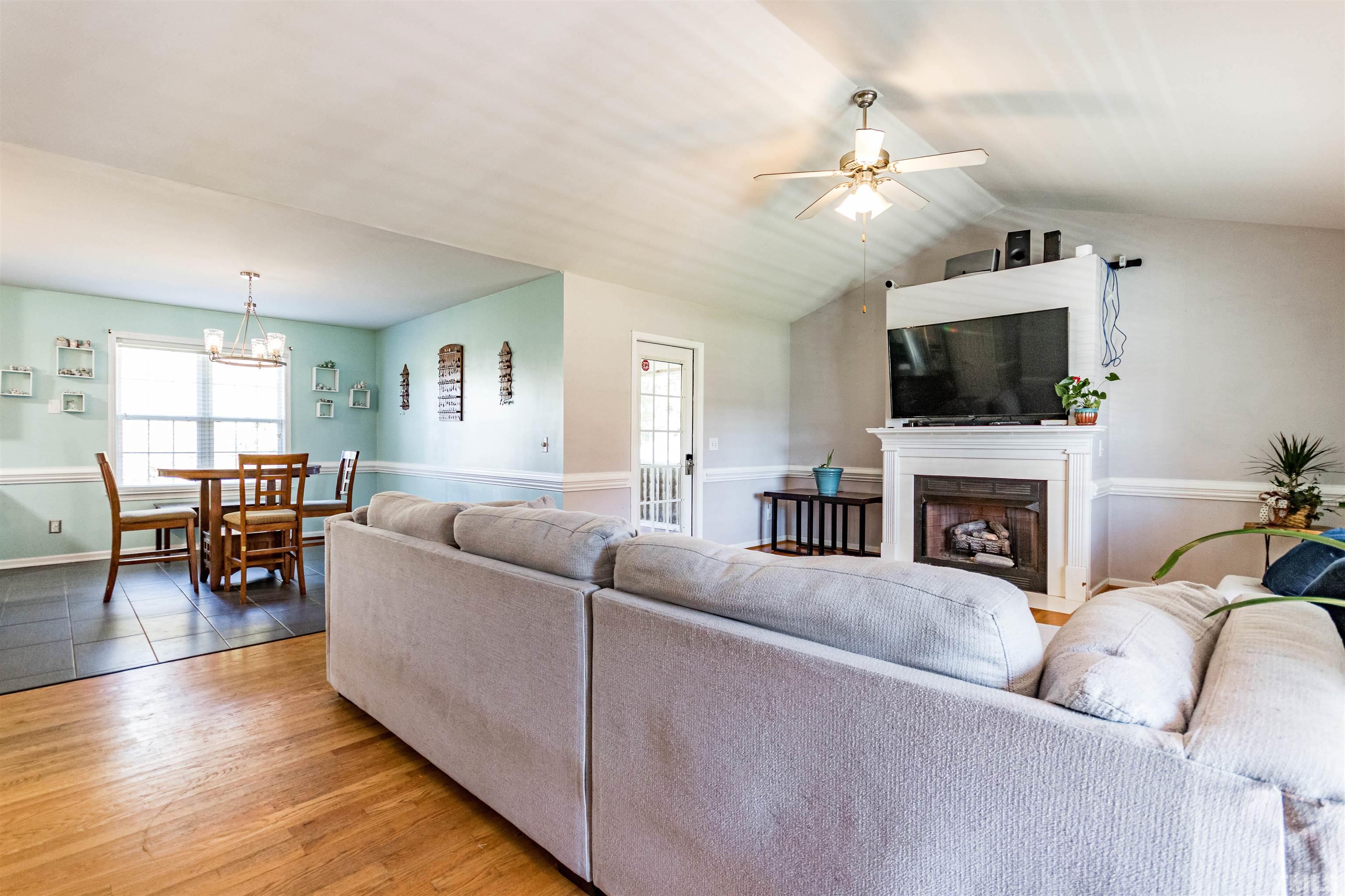519 Axum Road Willow Spring, NC 27592 - Photo 7 of 30 a living room with furniture a fireplace and a flat screen tv
