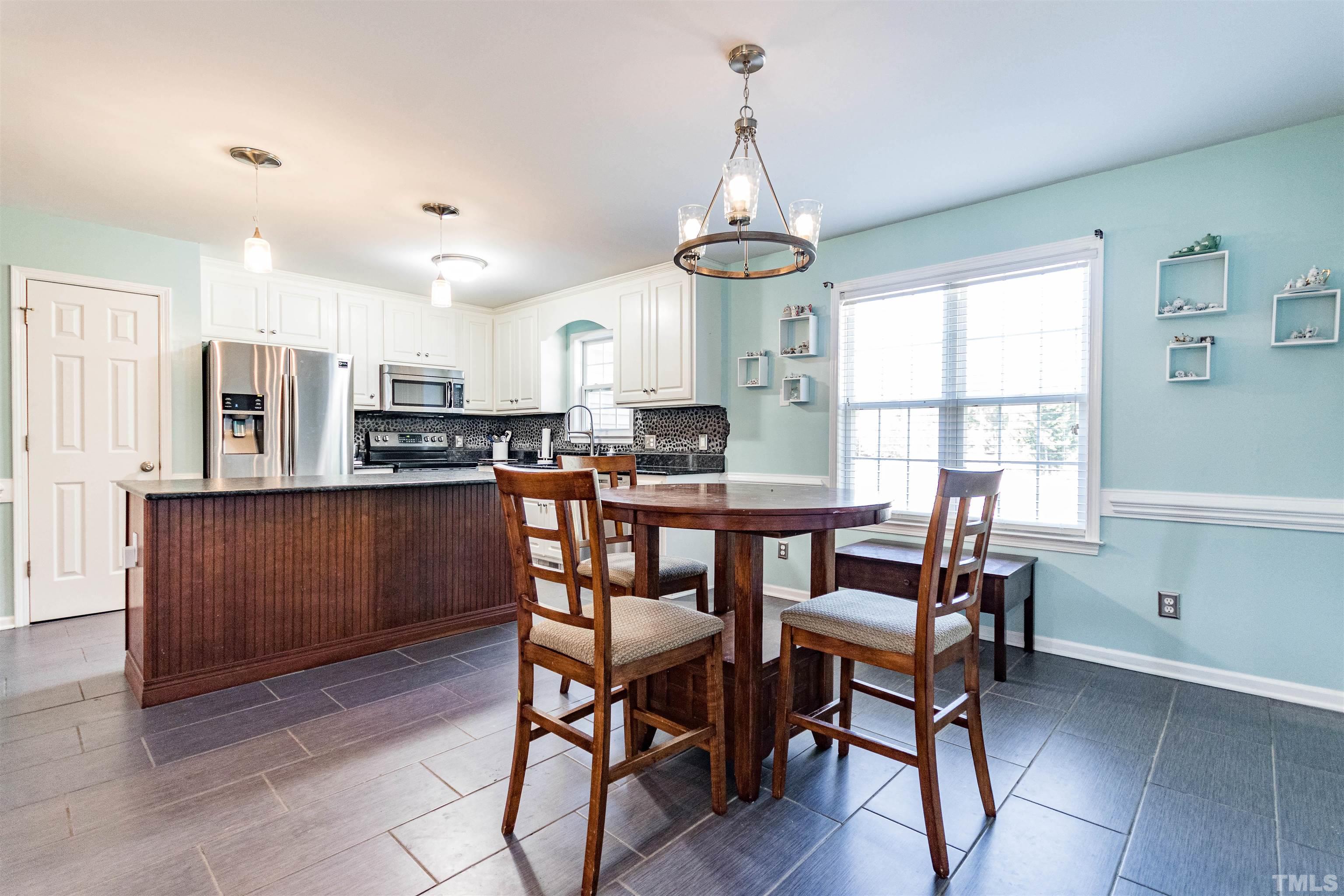 519 Axum Road Willow Spring, NC 27592 - Photo 10 of 30 a view of a dining room with furniture window and wooden floor