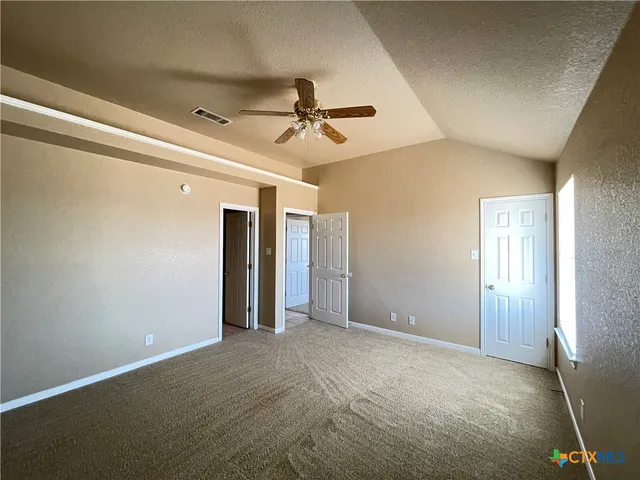 en empty room with closet and a ceiling fan