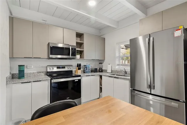 a kitchen with a refrigerator a stove top oven a sink and cabinets