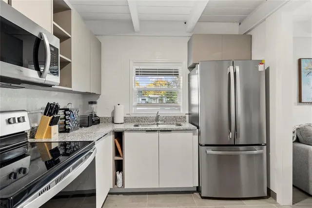 a kitchen with a refrigerator and a stove top oven
