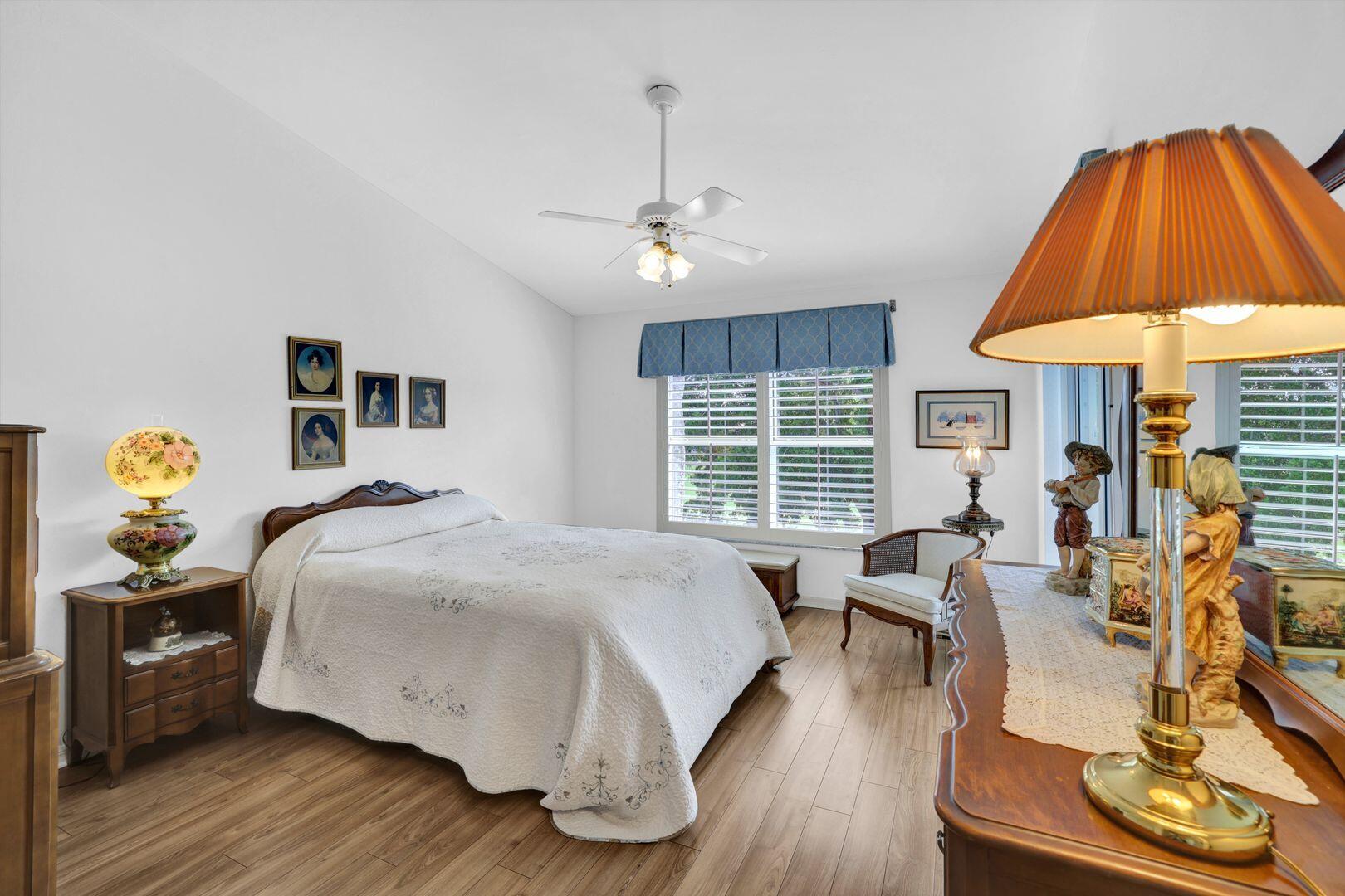 1006 Mainsail Drive, Unit 224 Naples, FL 34114 - Photo 13 of 30 a bedroom with a bed and a chandelier