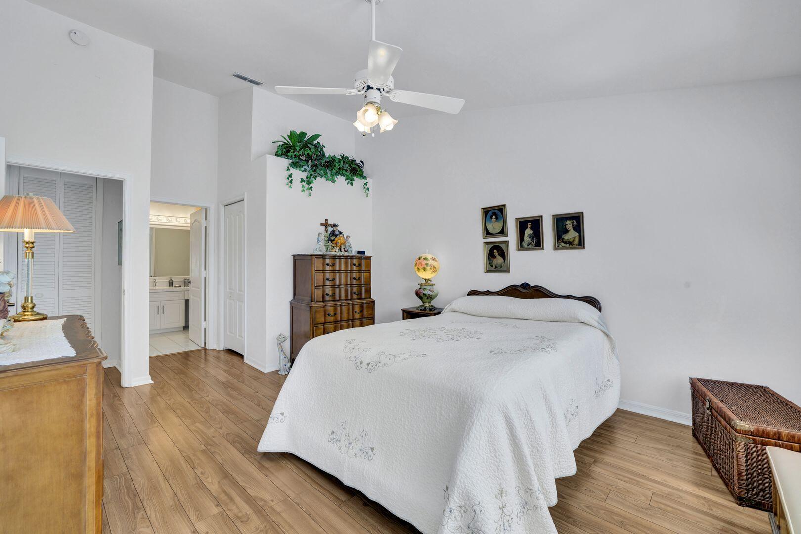 1006 Mainsail Drive, Unit 224 Naples, FL 34114 - Photo 14 of 30 a bedroom with a large bed and a chandelier