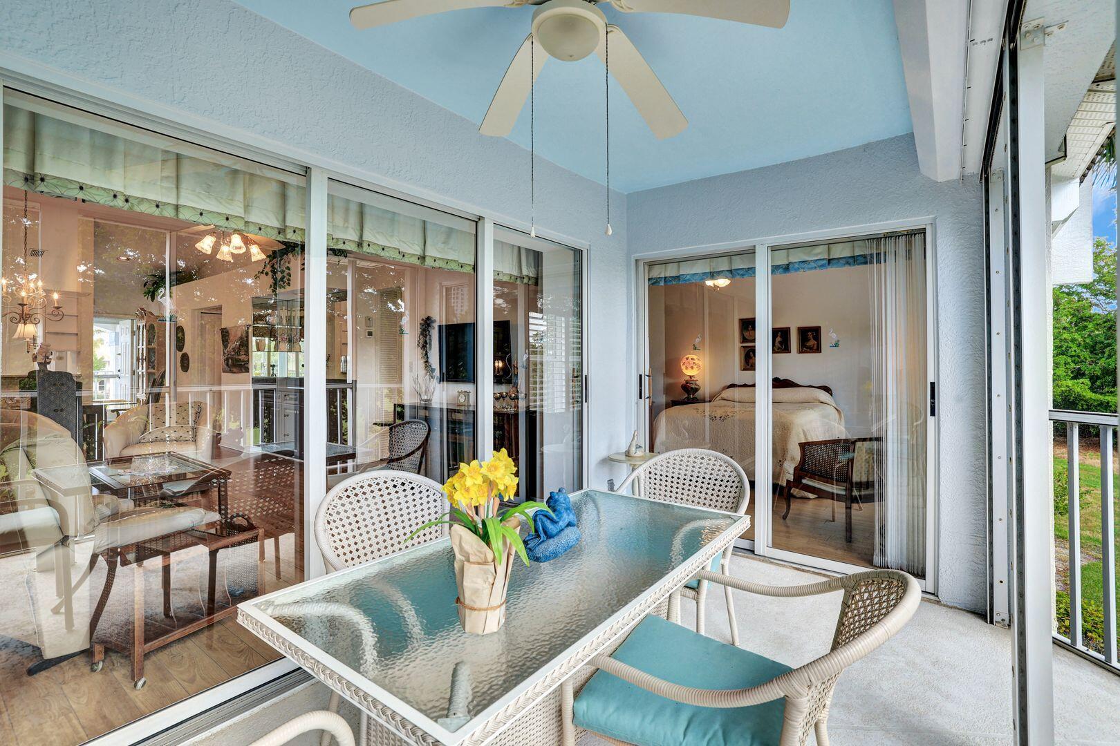 1006 Mainsail Drive, Unit 224 Naples, FL 34114 - Photo 20 of 30 a dining room with furniture a chandelier and wooden floor