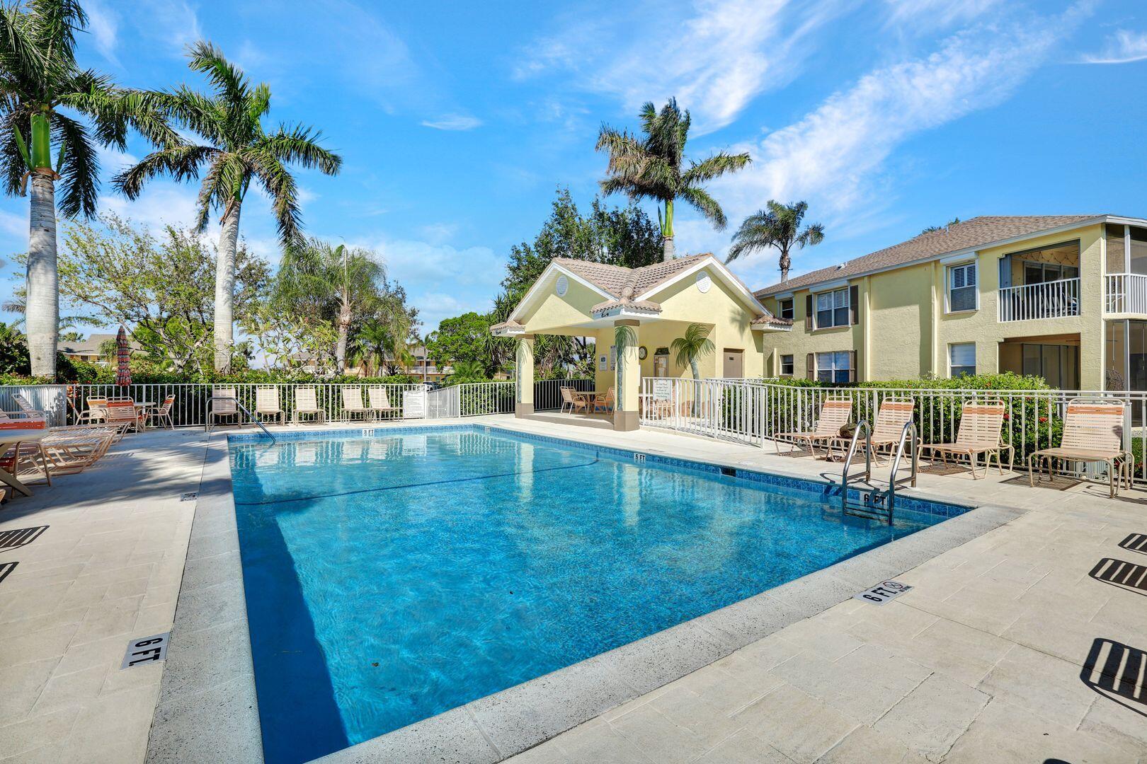 1006 Mainsail Drive, Unit 224 Naples, FL 34114 - Photo 26 of 30 a swimming pool with outdoor seating and yard