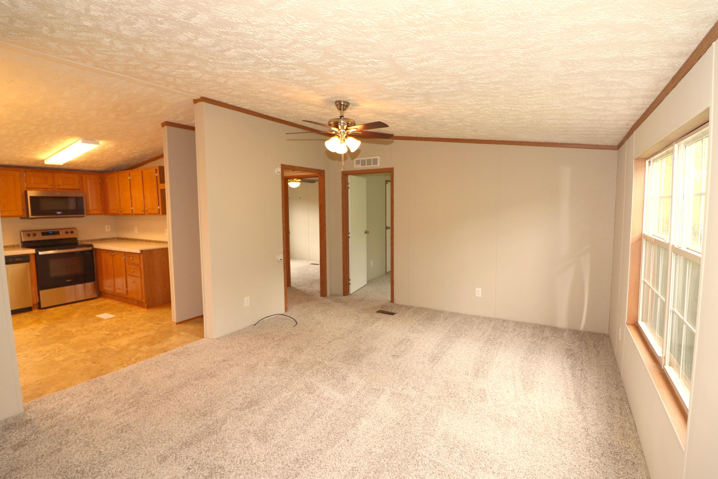 615 Edwards Road Penhook, VA 24137 - Photo 7 of 16 an empty room with chandelier fan and windows