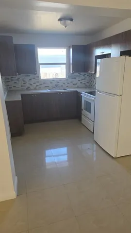 a kitchen with refrigerator and window