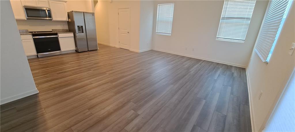 1683 Vernon Boulevard Decatur, GA 30035 - Photo 7 of 14 an empty room with wooden floor and a fireplace
