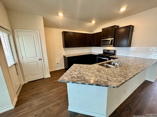 a kitchen with kitchen island granite countertop counter top space appliances and cabinets