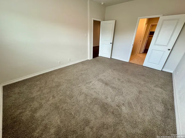 a view of a big room with wooden floor and windows