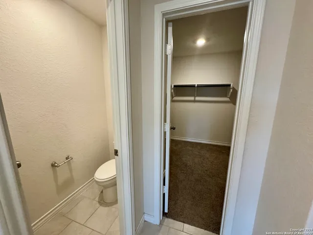a bathroom with a granite countertop toilet and a sink