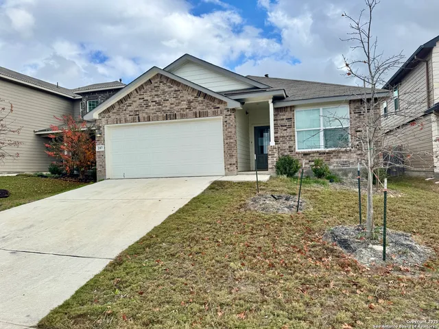 a view of a house with a small yard and potted plants