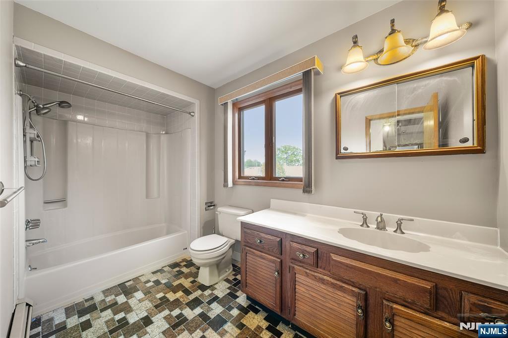 140 Allwood Road, Unit C Clifton, NJ 07012 - Photo 27 of 31 a bathroom with a sink a toilet a mirror a bathtub and shower