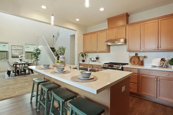 a kitchen with a sink a stove and chairs